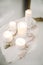 Burning candles of different sizes and praying rosary beads on stand of stone and concrete