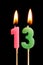 Burning candles in the form of 13 thirteen figures numbers, dates for cake isolated on black background. The concept of celebrat