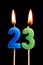 Burning candles in the form of 23 twenty three numbers, dates for cake isolated on black background. The concept of celebrating