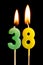 Burning candles in the form of 38 thirty eight numbers, dates for cake isolated on black background. The concept of celebrating