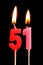 Burning candles in the form of 51 fifty one numbers, dates for cake isolated on black background. The concept of celebrating a b