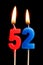 Burning candles in the form of 52 fifty two numbers, dates for cake isolated on black background. The concept of celebrating a b