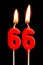 Burning candles in the form of 66 sixty six numbers, dates for cake isolated on black background. The concept of celebrating a b