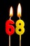 Burning candles in the form of 68 sixty eight numbers, dates for cake isolated on black background. The concept of celebrating a