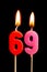 Burning candles in the form of 69 sixty nine numbers, dates for cake isolated on black background. The concept of celebrating a