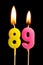 Burning candles in the form of 89 eighty nine numbers, dates for cake isolated on black background. The concept of celebrating a