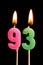 Burning candles in the form of 93 ninety three numbers, dates for cake isolated on black background. The concept of celebrating