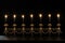 Burning candles in a golden candelabra on a black background