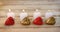 Burning candles with heart shape pendant on wooden plank