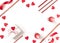 Burning candles, heart-shaped figures, wooden sticks, ribbon, gift in crumpled wrapping paper are on a white background.