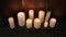 Burning candles near a metal wall on wooden floor. Slow panning shot