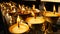 Burning candles in temple. View of golden shiny bowls with burning flame of oil candles for worship.