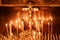 Burning candles in the temple, wax candles lit against the background of a cross with a crucifix, the concept of christian religio