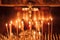 Burning candles in the temple, wax candles lit against the background of a cross with a crucifix, the concept of christian religio