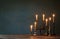 burning candles in vintage candlesticks on dark background