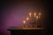 burning candles in vintage candlesticks on dark background