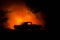 Burning car on a dark background. Car catching fire, after act of vandalism or road indicent