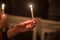 burning church candles in the hands of children on a dark background