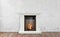Burning classic fireplace of white marble. Empty living room on background