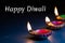 Burning decorated ceramic oil lamp diya, on Happy Diwali, Shubh Diwali meaning with beautiful dark blue background