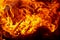 Burning fire close up. Bright orange and red flames on a dark background. Open flame heating. Problems with heating and gas