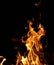 Burning fire with smoldering logs on a dark night
