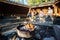 Burning Firepit With Friends Preparing Food In Shed