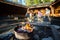 Burning Firepit With Friends Preparing Meal In Shed