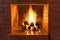 Burning firewood in a red brick fireplace in a country cottage