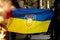 Burning flag of Ukraine with symbol or logo of Luhansk or Lugansk city