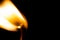 Burning flame on an isolated match stick on a black background