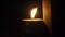 Burning flat candle at night on dark background