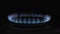 Burning gas on the kitchen stove in the dark, close-up. The concept of the rise in price of energy resources and the