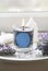 Burning glass candle with homemade sign showing Flower of Life symbol in home interior with semi precious stone geodes.