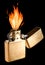 Burning golden metal gas lighter on black background