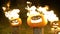 Burning halloween pumpkins on tree log in darkness, field, mist, dusk. Scary funny angry big orange pumpkin exhales fire