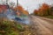 Burning leaves, fire while cleaning the garden. Autumn chores on the farm.