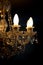 A burning light bulb on a crystal chandelier on a dark background