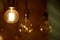 A burning light bulb glows faintly against the background of blurry yellow lights. Energy crisis. Blackout