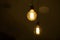 A burning light bulb glows faintly against the background of blurry yellow lights. Energy crisis. Blackout