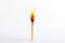 A burning matchstick against a plain white background