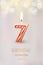 Burning number 7 birthday candle with birthday celebration text on light blurred background. Vector seventh birthday