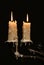 Burning old candle vintage Silver bronze candlestick. Isolated Black Background.