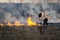 Burning old, dry grass field in the spring, Firefighters work