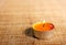 Burning orange candle placed on jute material