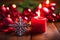 A burning red candle and an array of festive Christmas decorations