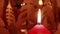 Burning red candle with silent flame in front of a rotating pyramid