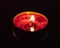 Burning red tealight candle