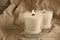 Burning soy candles with wooden wicks on crumpled kraft paper