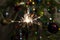 Burning Sparkler fire amid Christmas tree lights